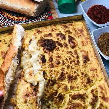A tray of baked chickpea custard with a dark golden, blistered top.